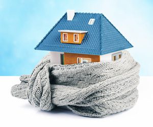 Small model of a home wrapped in a grey scarf.