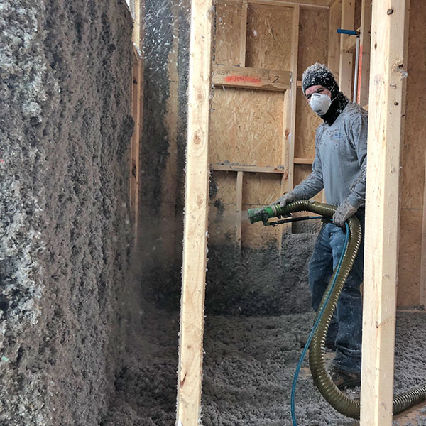 Worker Installing Cellulose Wall Insulation