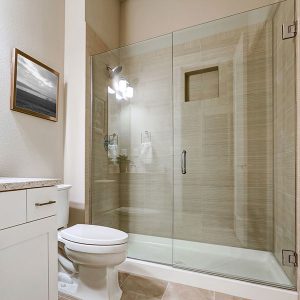 Hybrid glass shower door in an off-white bathroom.